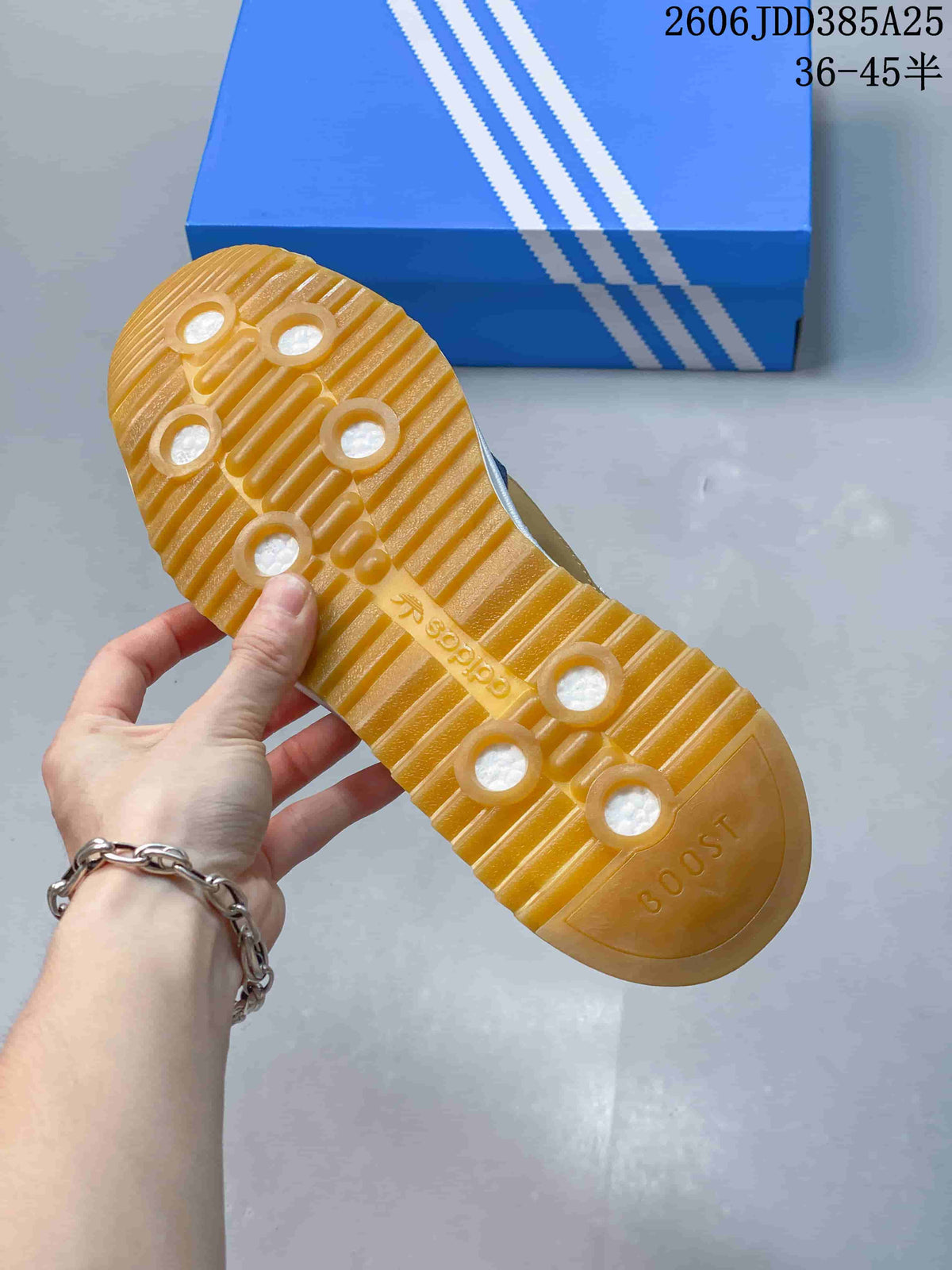 Gum-colored outsole with ridged tread and circular cutouts.