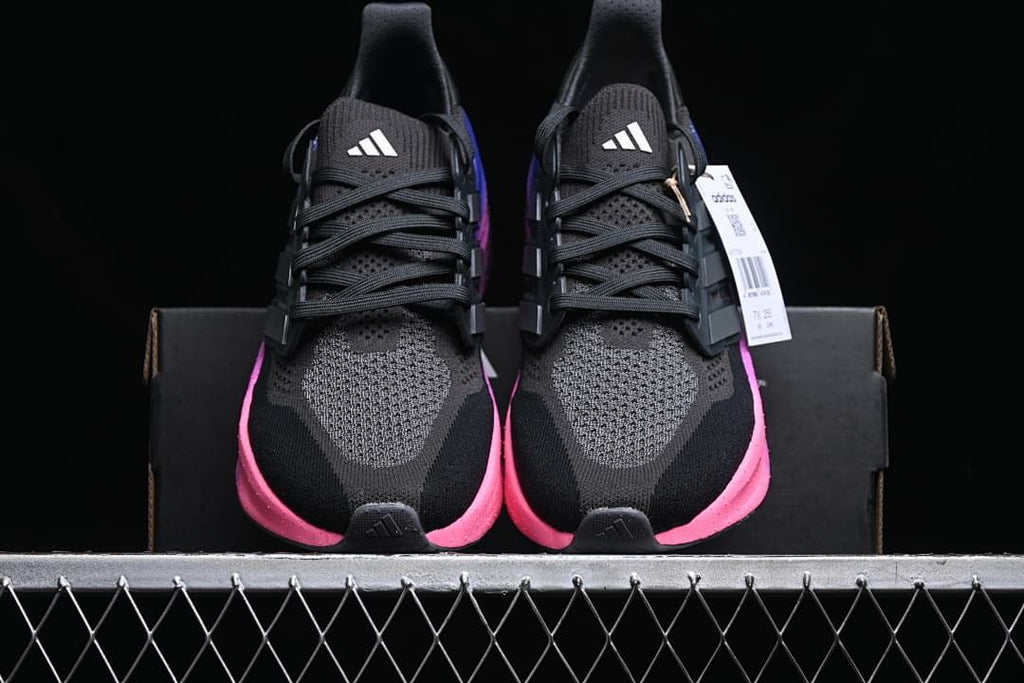 Front view of the pair showing the black uppers and pink midsole accents