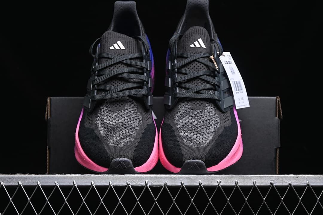Front view of the pair showing the black uppers and pink midsole accents