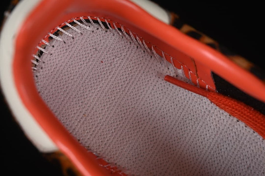 Close-up of the sneaker's inner lining, stitching, and orange-red lace
