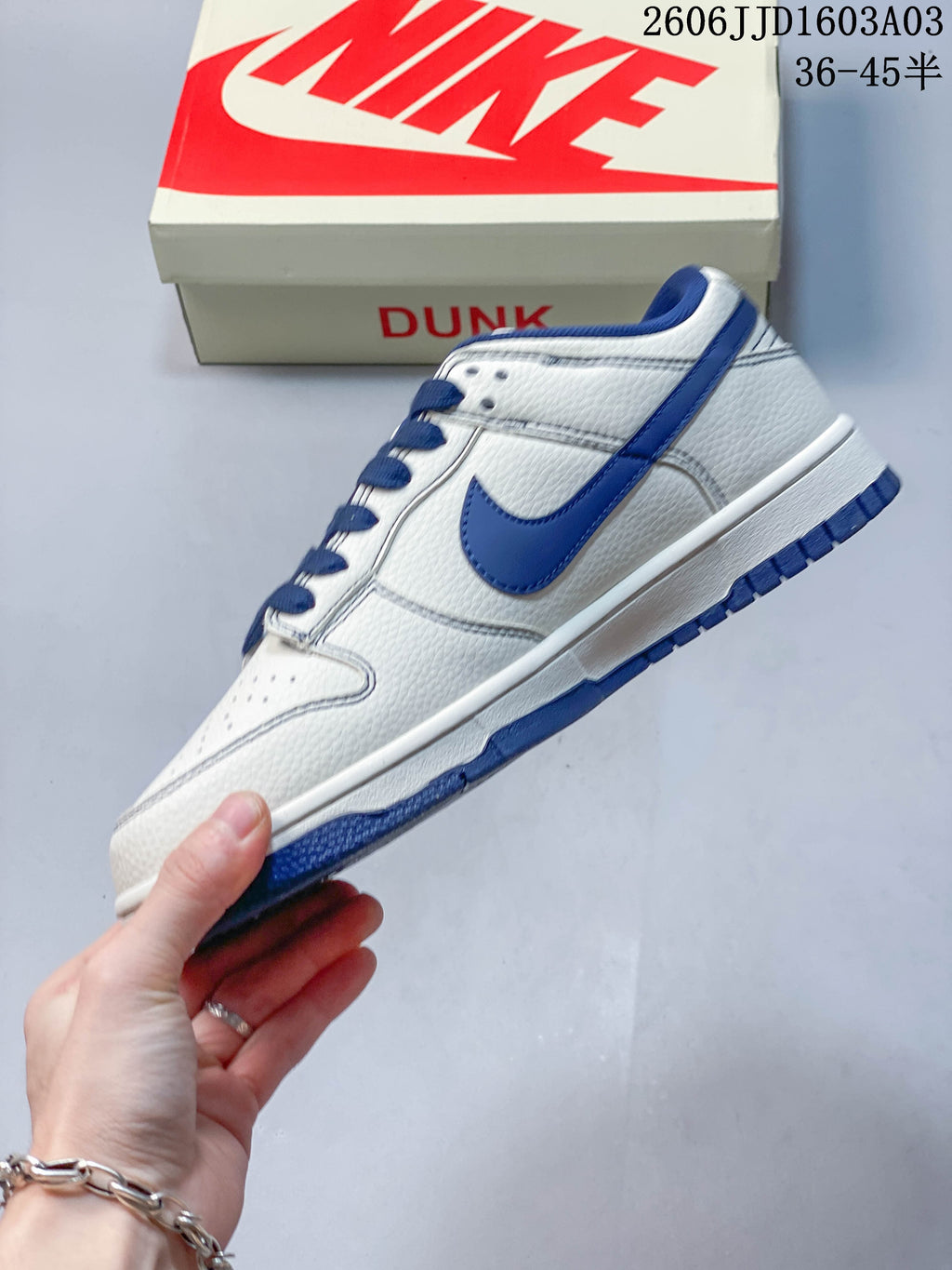 Side view of a white and blue low-top sneaker with blue Swoosh accent
