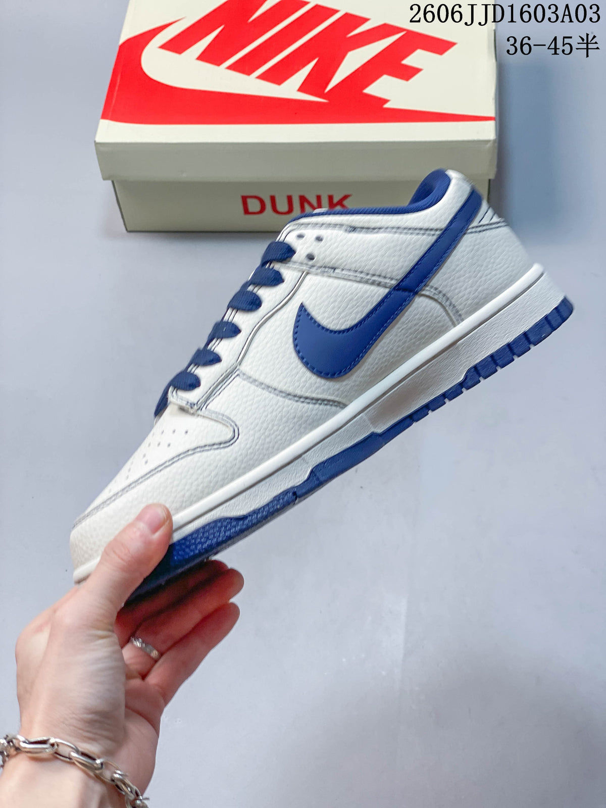 Side view of a white and blue low-top sneaker with blue Swoosh accent