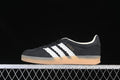 Side view of black Adidas Gazelle Indoor sneakers with white stripes and a gum-colored sole.