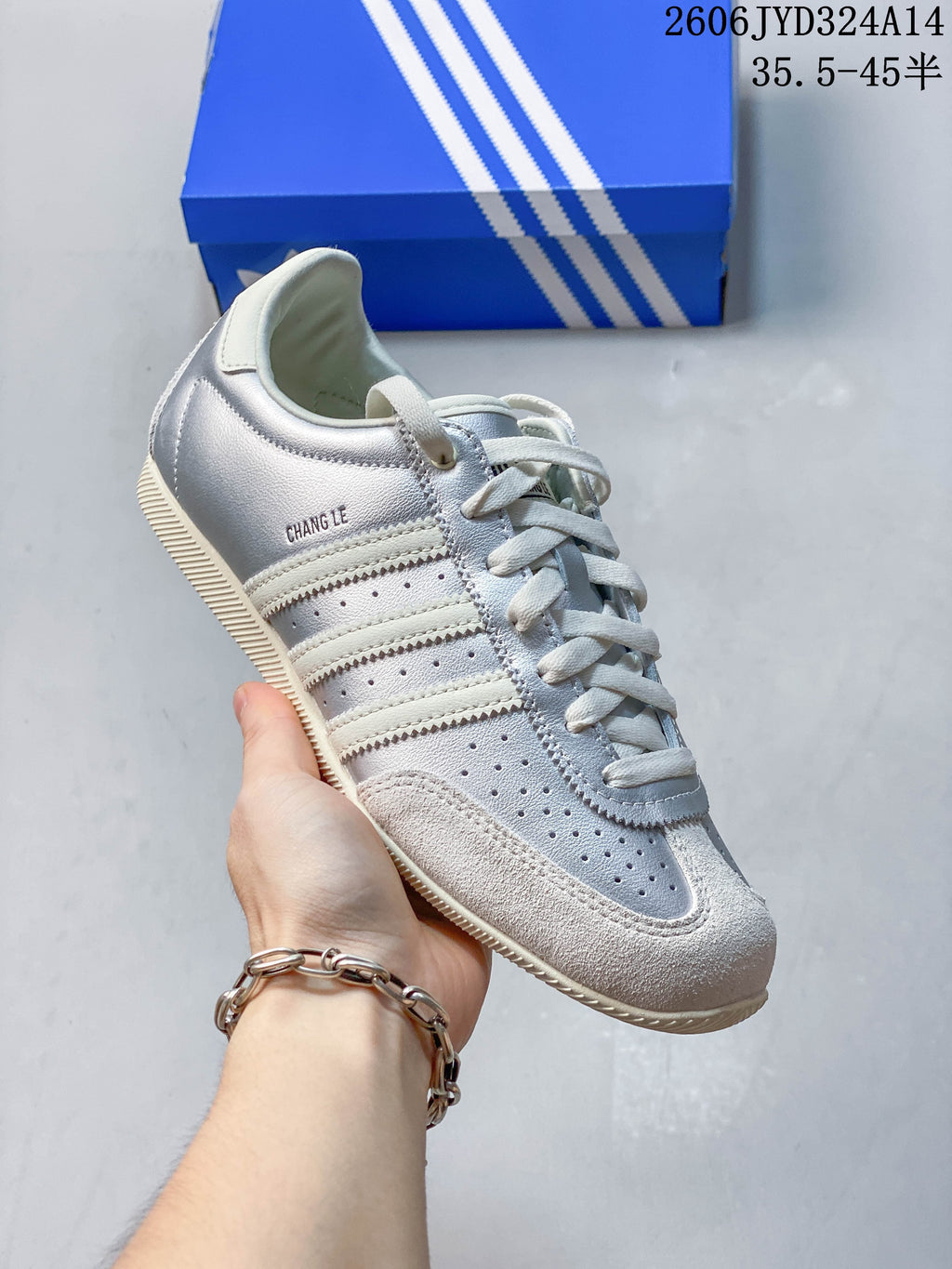 Angled side view of a silver Adidas CHANGLE sneaker with perforated panels