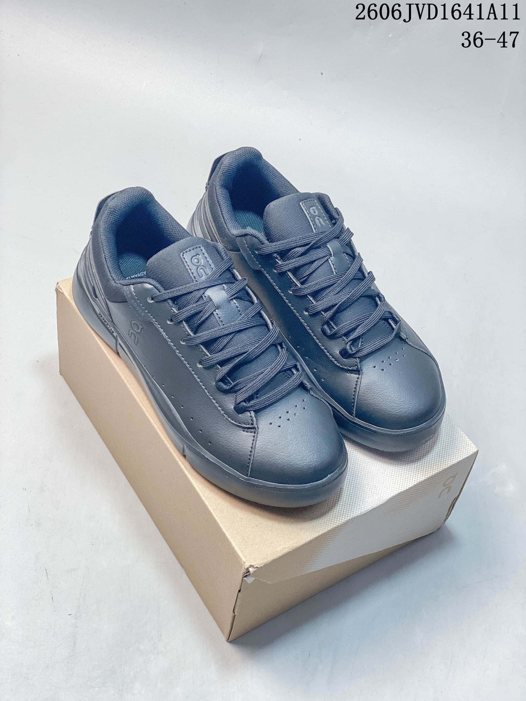 Pair of slate-blue On low-top lace-up sneakers displayed on a box