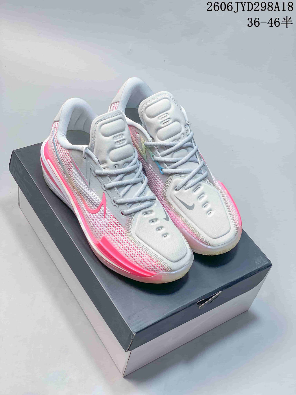 Pair of white and pink Nike Air Zoom GT Cut low-top shoes shown from above on a box.