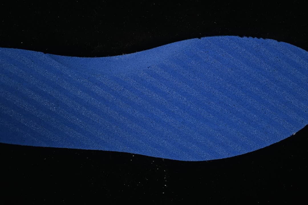 Close-up of a blue shoe component with a textured surface