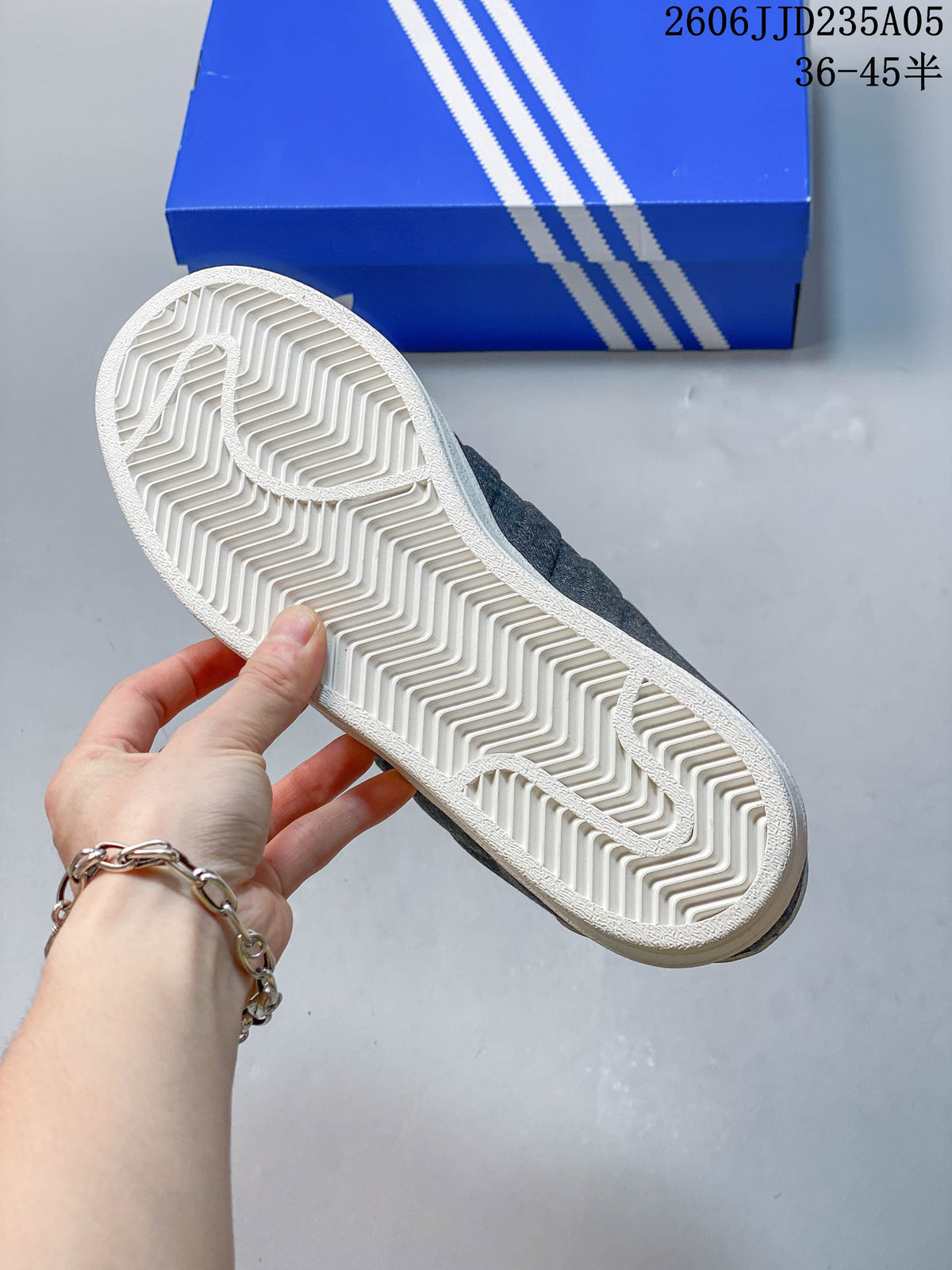 View of the white rubber outsole and patterned tread on a gray low-top sneaker