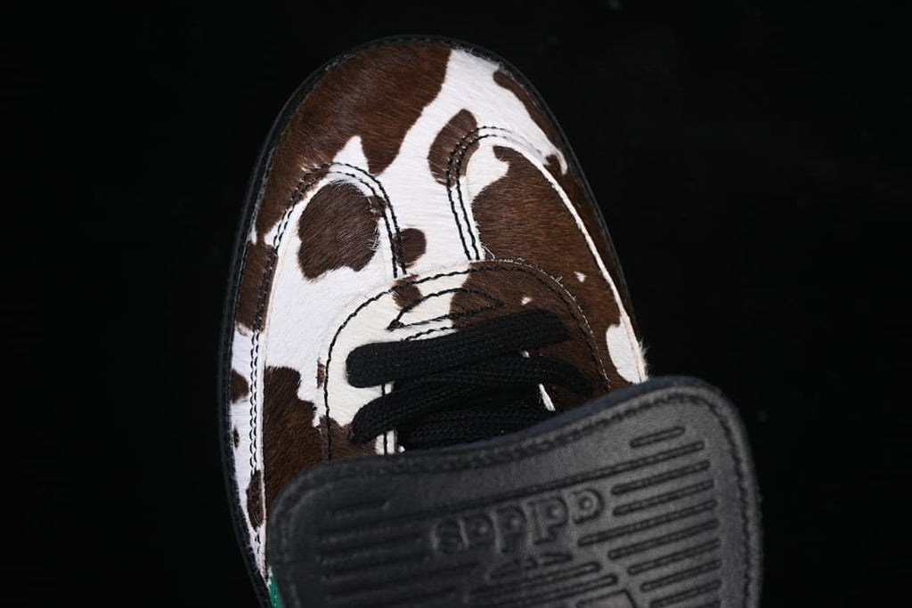 Top view of the cow-print toe, black laces and fold-over tongue flap