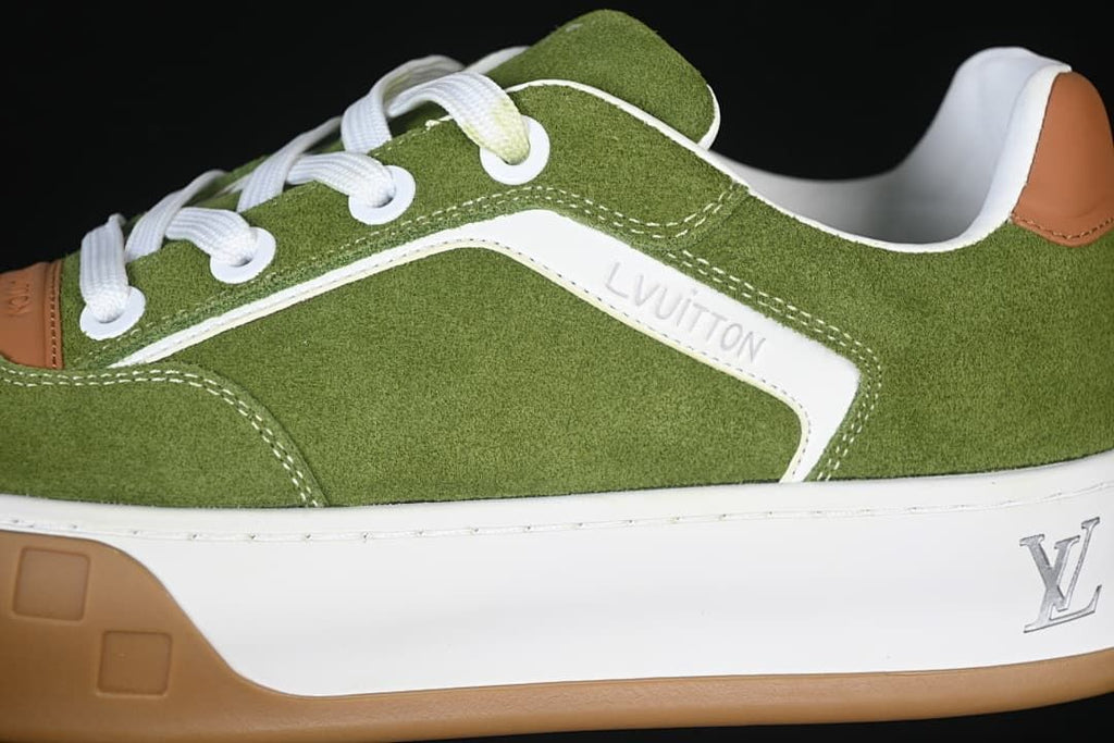 Close-up of green upper, white side panel, laces, and tan outsole