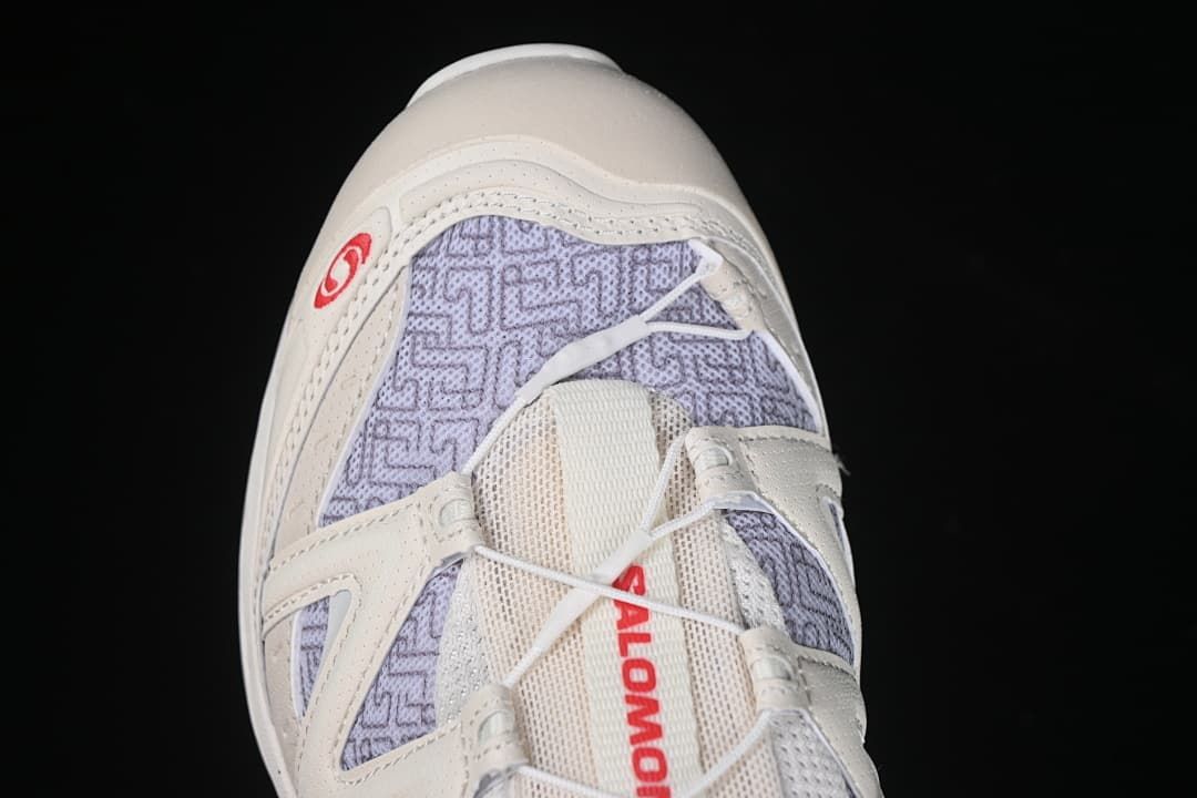 Top-down close-up of the shoe's tongue, laces and lavender patterned panels.