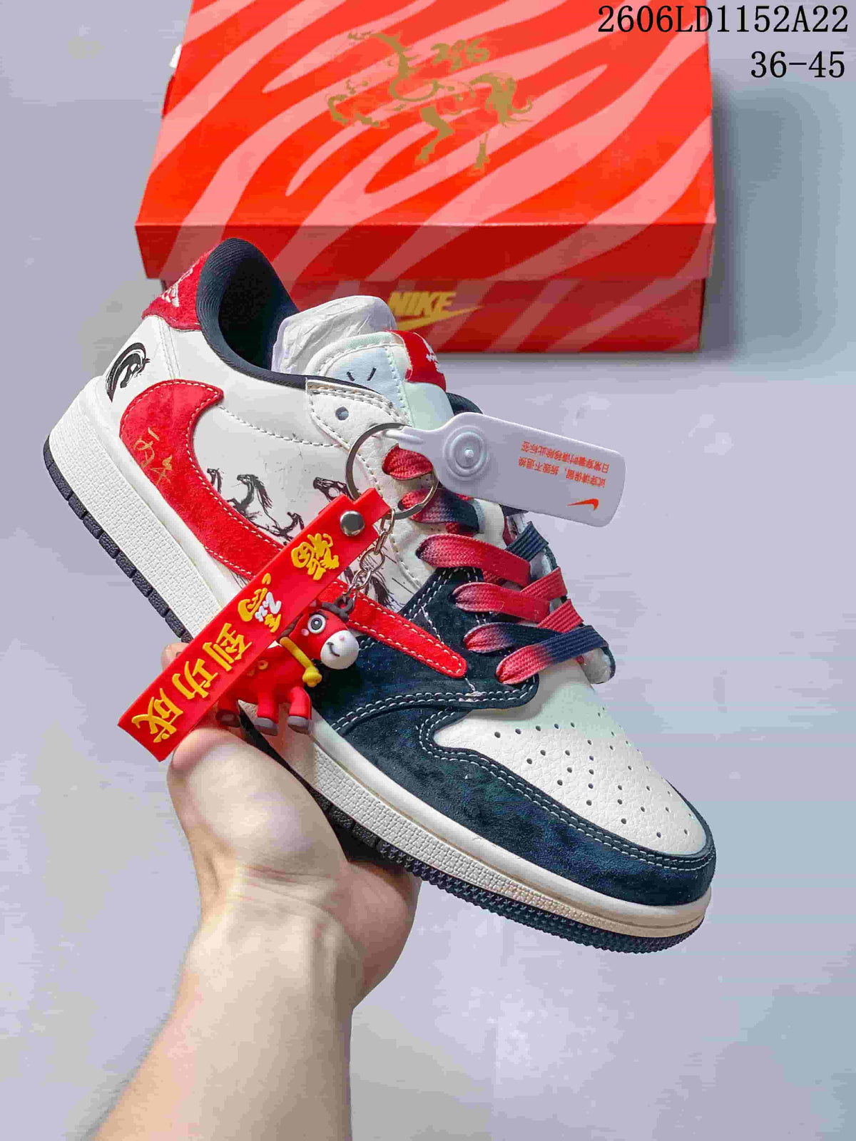 Low-top sneaker with white, red, and navy panels, graphic details, and decorative red charm; size range 36–45 is printed in the image.
