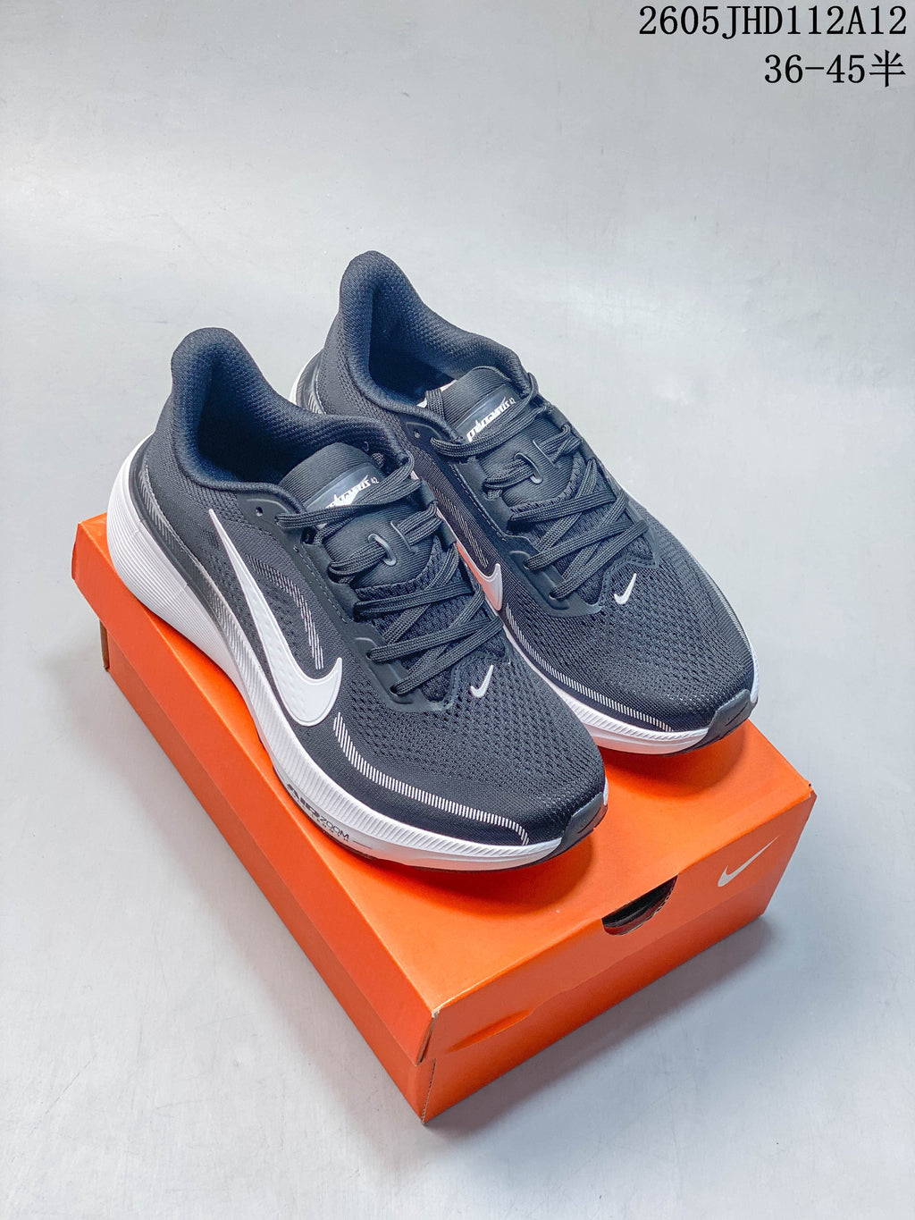 Pair of dark gray Nike Air Zoom Pegasus 42 shoes on an orange shoebox