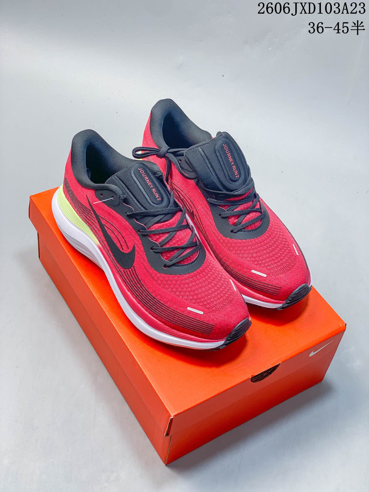 Red Nike running shoes with black accents, shown on an orange shoe box.