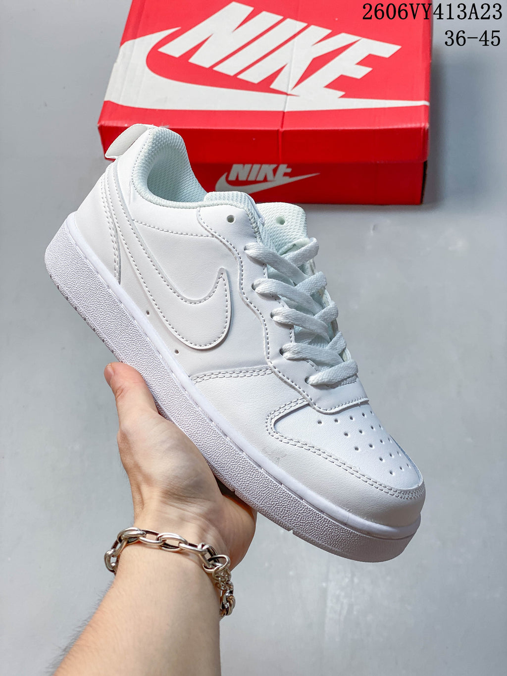 White low-top sneaker with a tonal white Swoosh and perforated toe
