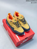 Pair of yellow and dark Nike sneakers with orange lining, displayed on a red shoebox