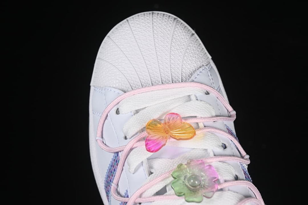 Top view of the shell toe, pink cord and colorful lace ornaments