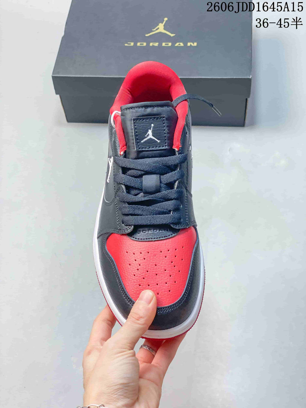 Front view of a Jordan Court Connect sneaker showing its perforated red toe and navy laces