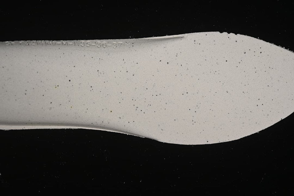 Close-up of the sneaker insole showing a faint size marking; the markings are not clear enough to establish a size range.