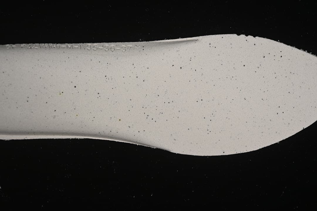Close-up of the sneaker insole showing a faint size marking; the markings are not clear enough to establish a size range.