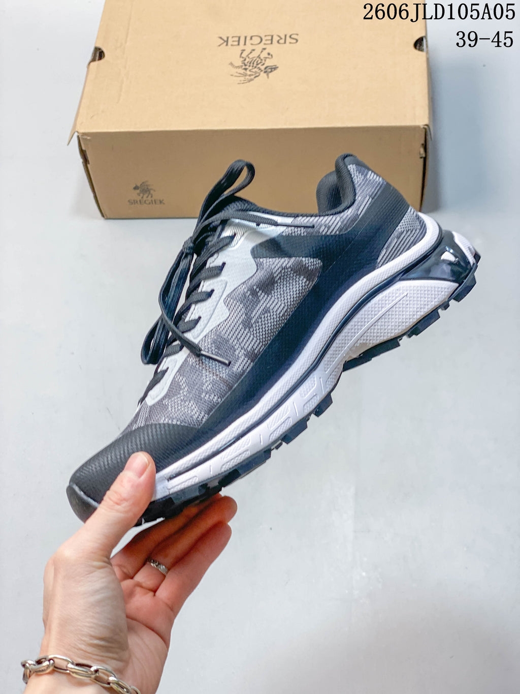 Side view of the gray and navy lace-up trail sneaker.