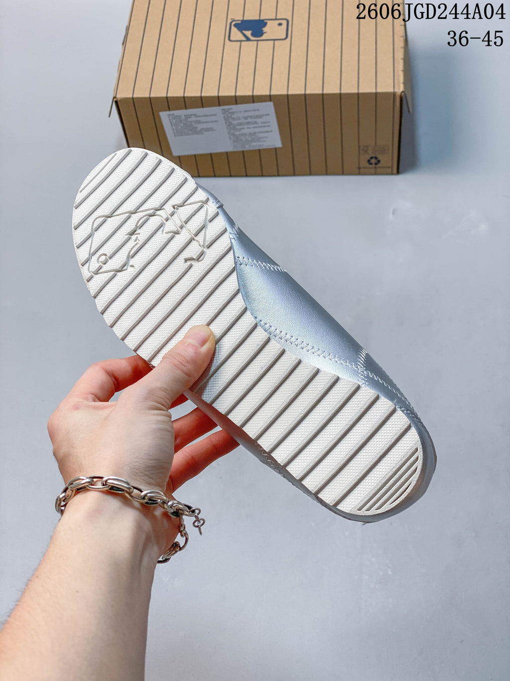 Close-up of the white textured outsole on a silver sneaker