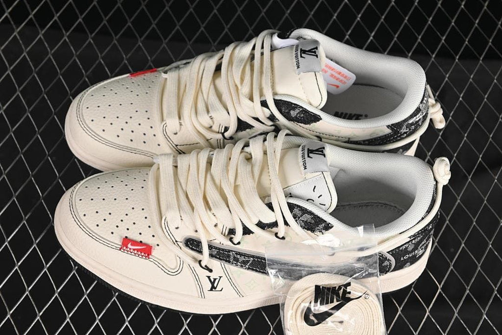 Top view of a pair of off-white and black low-top sneakers with patterned panels and an extra lace set shown in packaging.