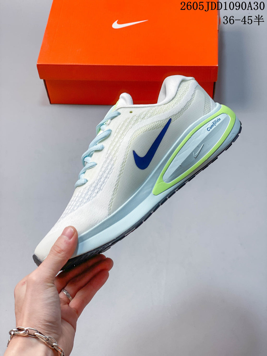 Side view of the white Nike Journey Run shoe with blue and lime details.