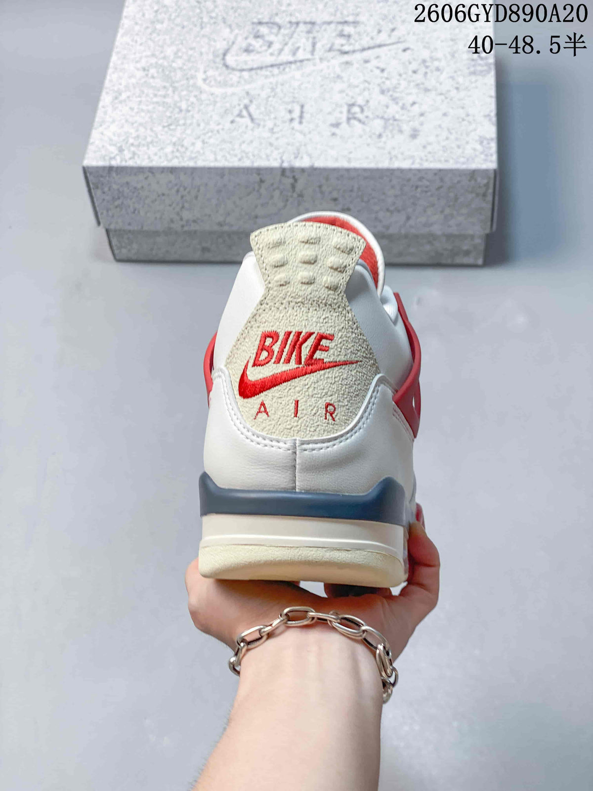 Rear view of a white and red Air Jordan 4 Retro sneaker