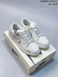 Pair of white and navy Nike Dunk Low Retro sneakers on a shoebox