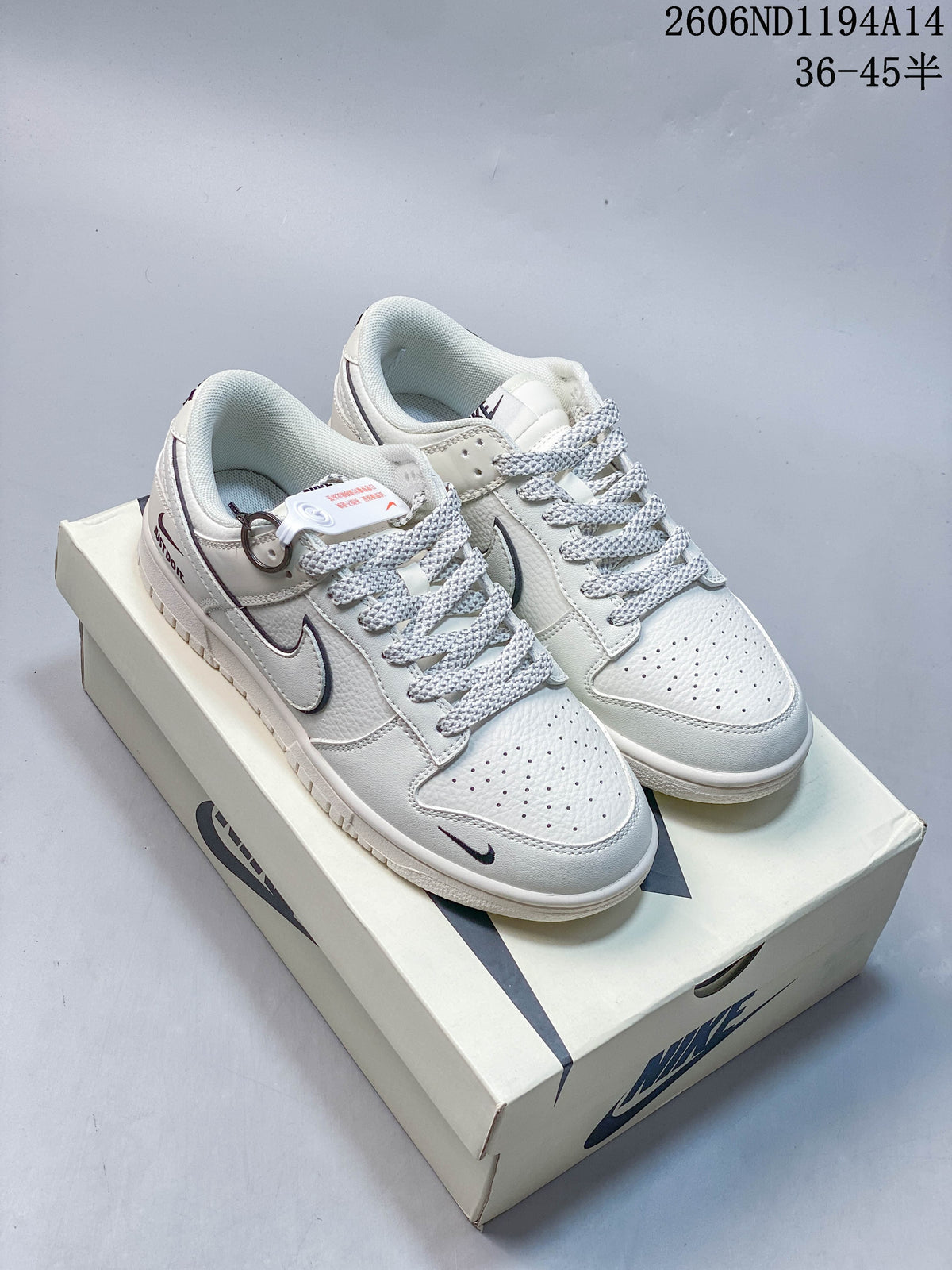 Pair of white and navy Nike Dunk Low Retro sneakers on a shoebox