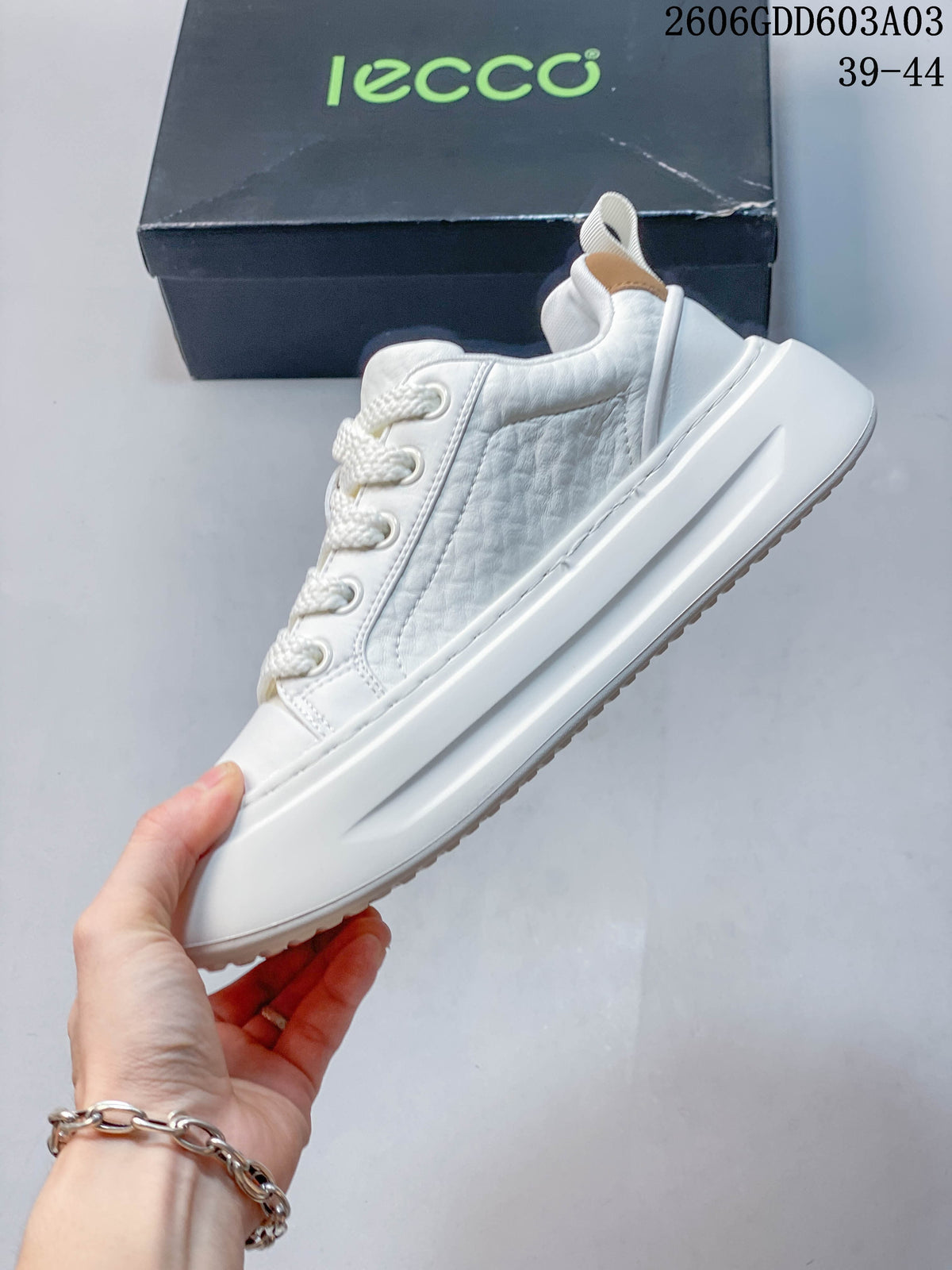 Side profile of the white low-top sneaker showing textured panels and a thick sculpted sole; image overlay states sizes 39–44.