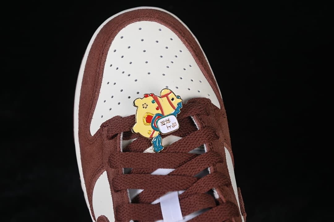Top view of perforated white toe box, brown overlays, and horse-themed lace charm