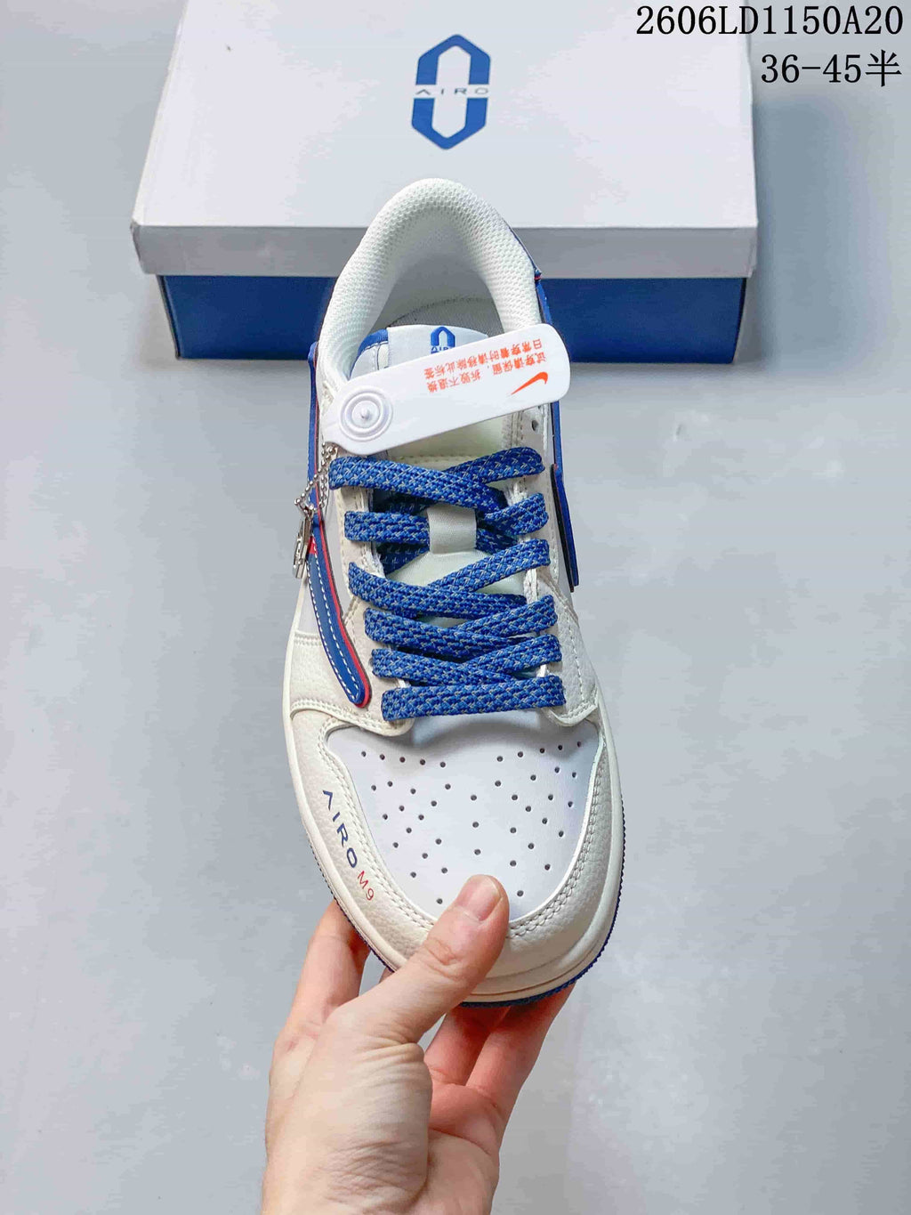 Top view of a white sneaker showing blue laces and a perforated toe.