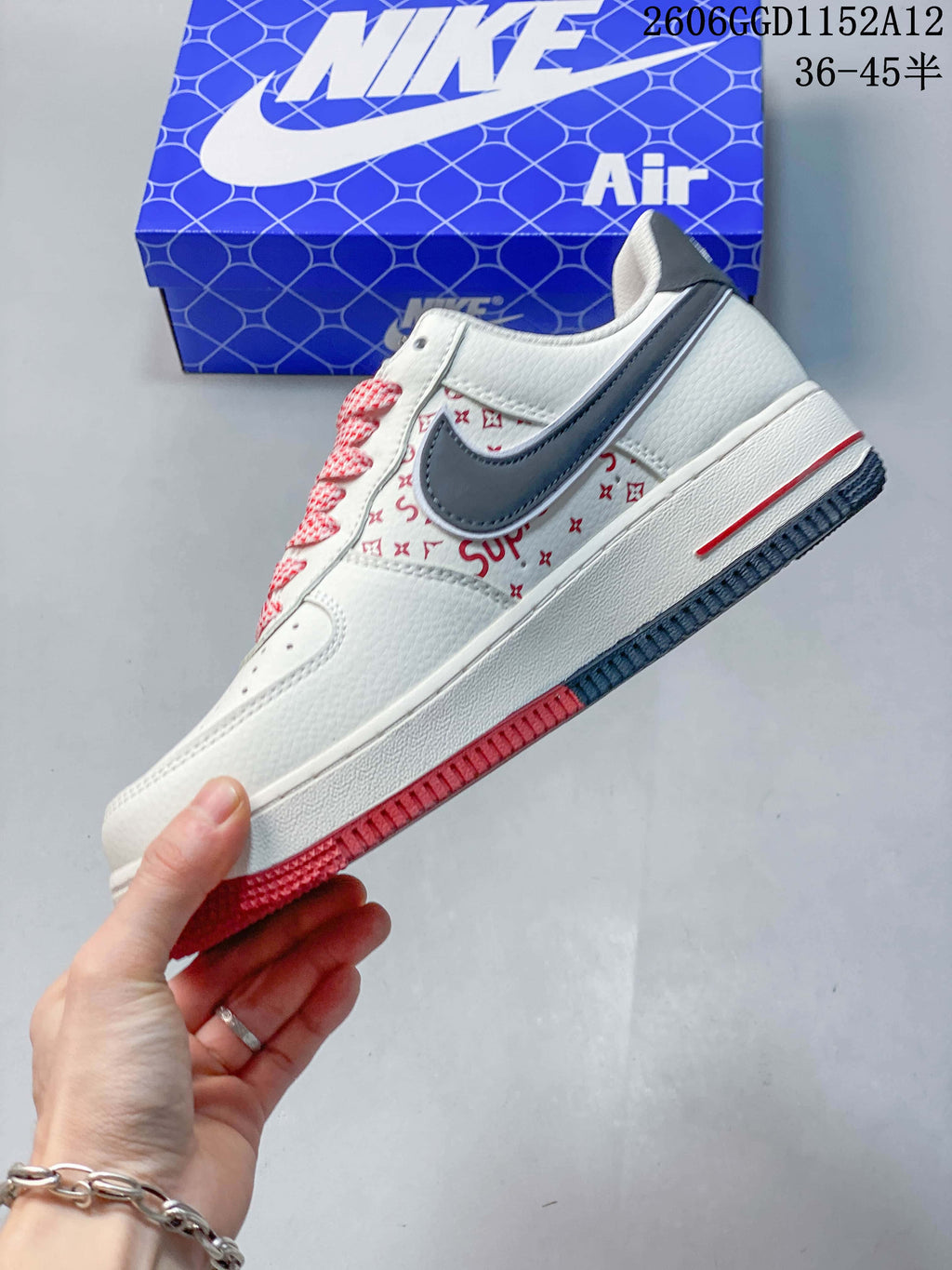 Side view of the sneaker with a gray swoosh, red printed details and contrasting outsole