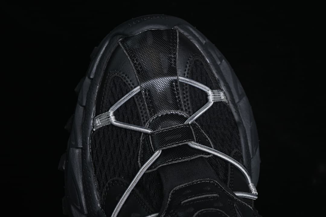 Top view of the black sneaker with cord lacing across the forefoot.