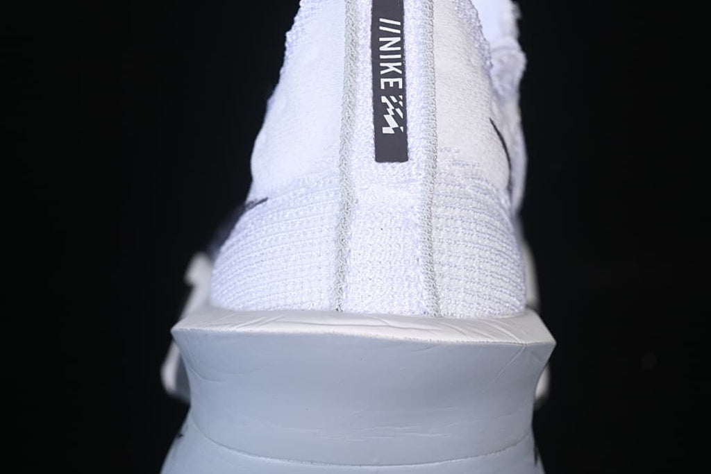 Rear view of the white shoe with heel pull tab and raised sole