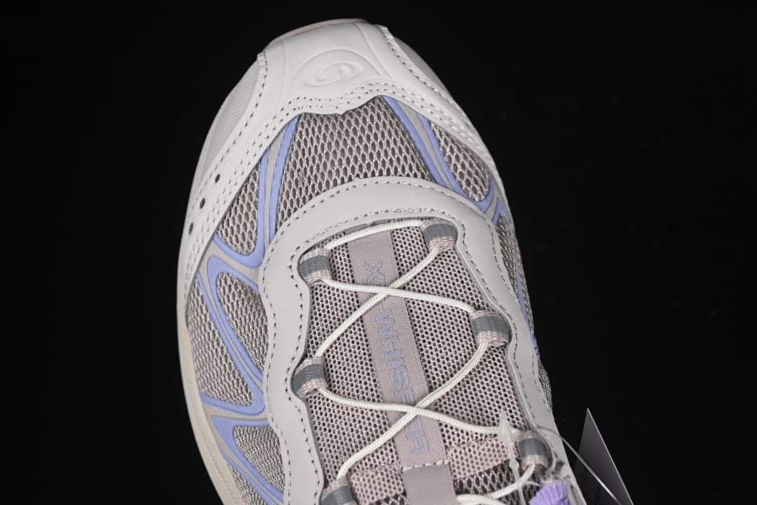 Top-down view of the toe and cord lacing on the gray shoe.