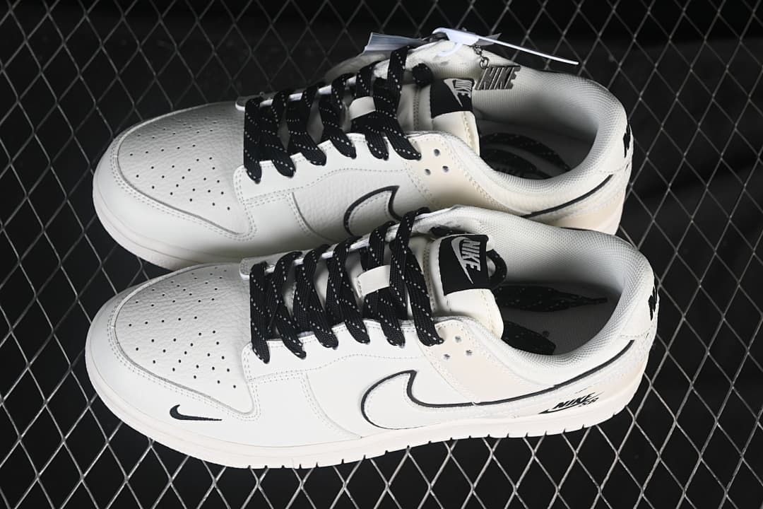 Pair of off-white Nike SB Dunk Low sneakers with black laces, perforated toe boxes, and black logo details
