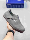 Gray closed-toe clog with two buckle straps; a box is visible in the background.