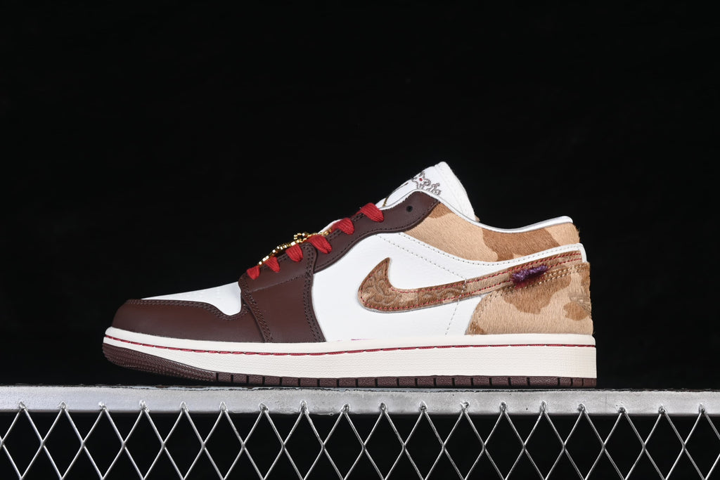 Side profile of the low-top sneaker with white, brown, tan, and red accents