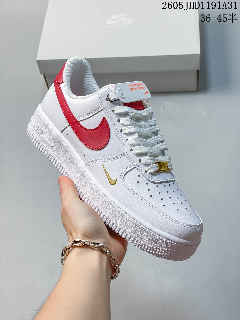 Angled view of the white sneaker with red Swoosh and heel accents