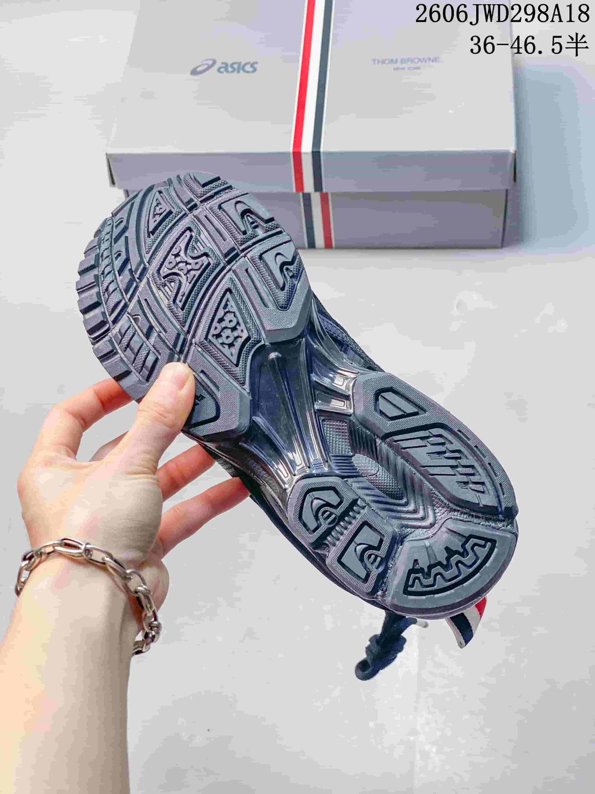 Outsole view showing the patterned tread of a dark gray ASICS sneaker
