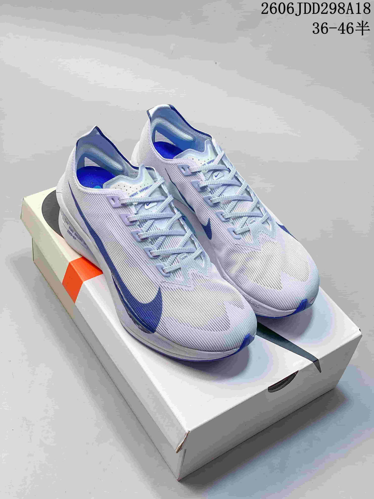 Lavender and blue Nike ZoomX Vaporfly Next% 4 shoes displayed on a box.