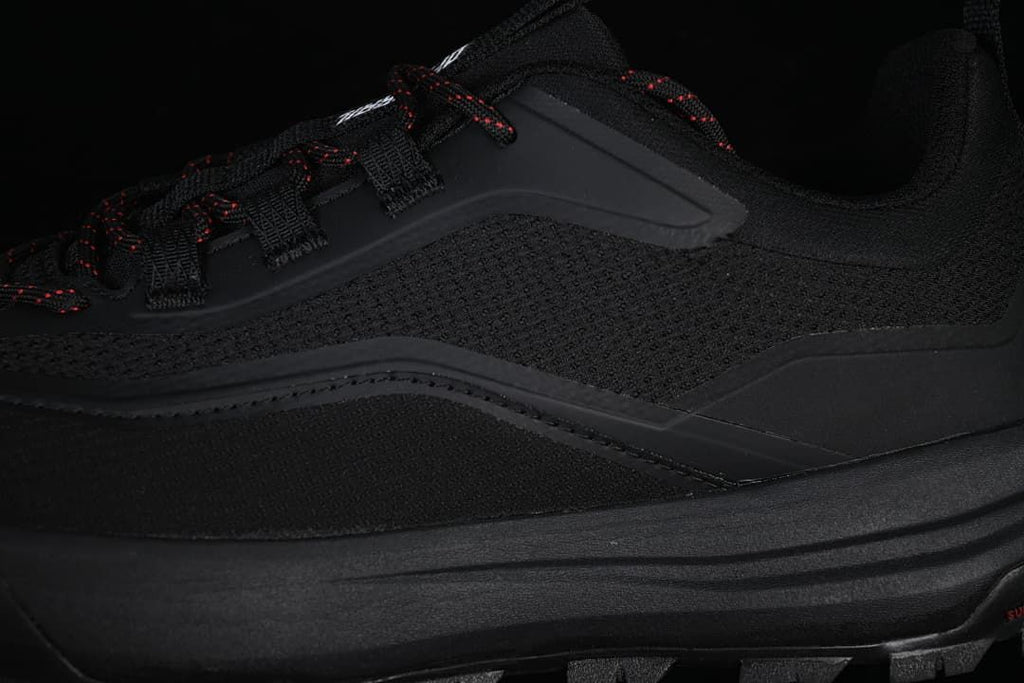 Close-up of the textured side panel, lace loops and red-accented laces