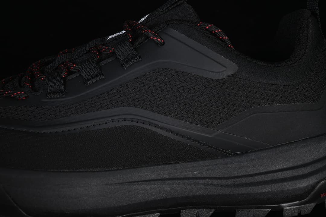 Close-up of the textured side panel, lace loops and red-accented laces