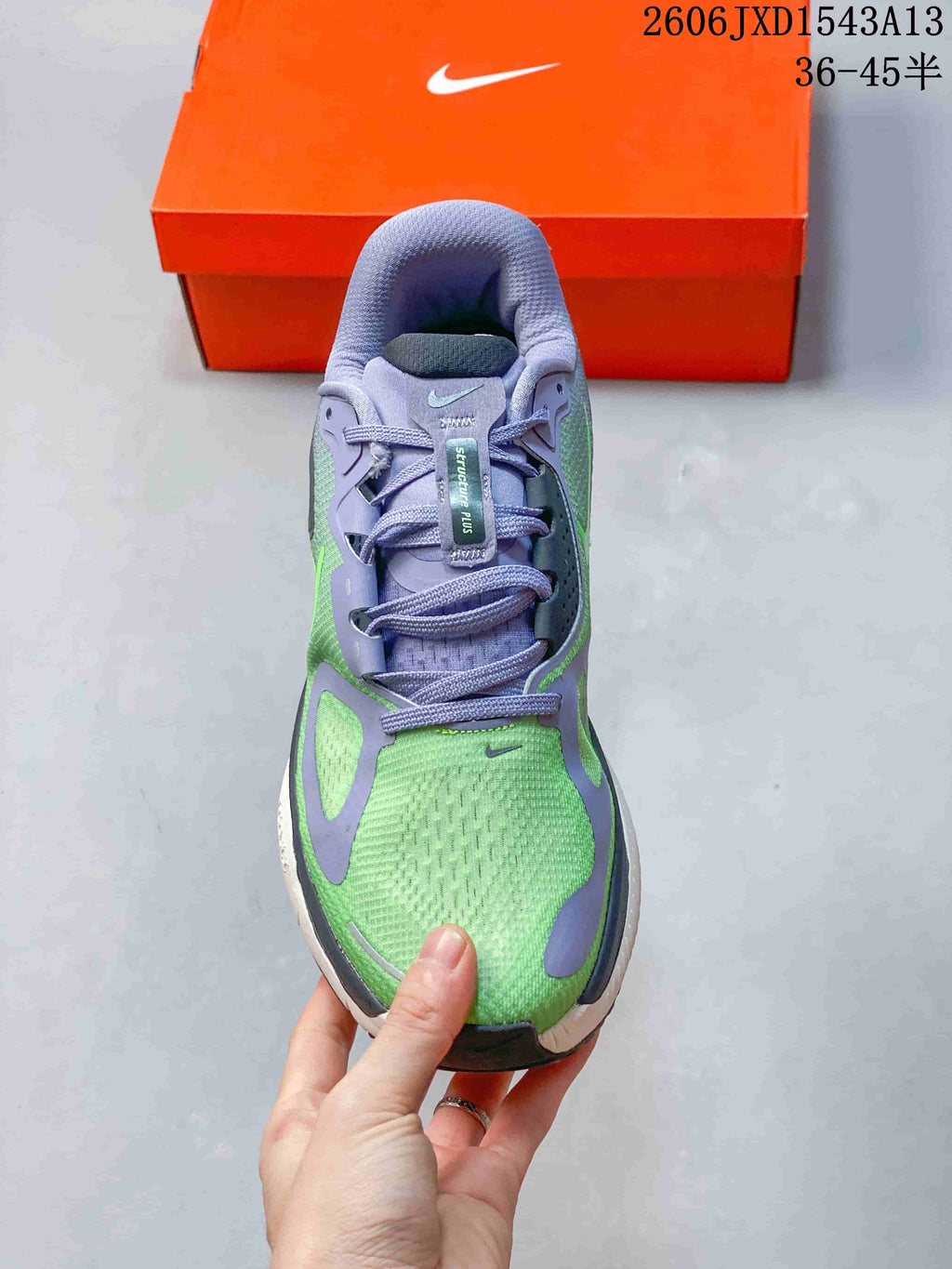 Top view of a Nike Structure Plus running shoe with green panels, lavender overlays, and laces.