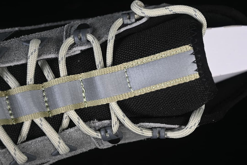 Close-up of the lace area, tongue, and reflective-looking central strip.