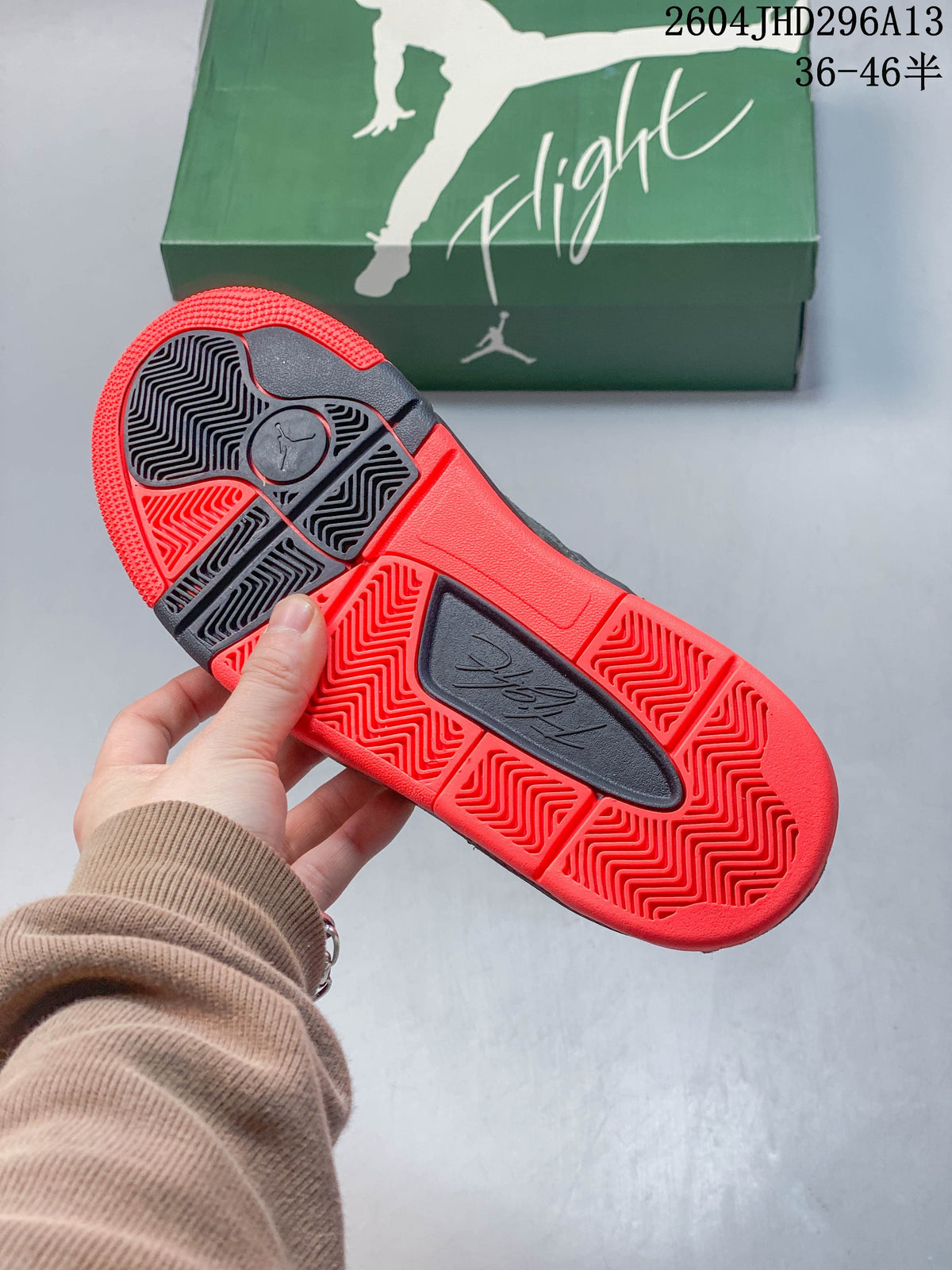 Close-up of the sneakers' red and dark outsole with patterned tread.