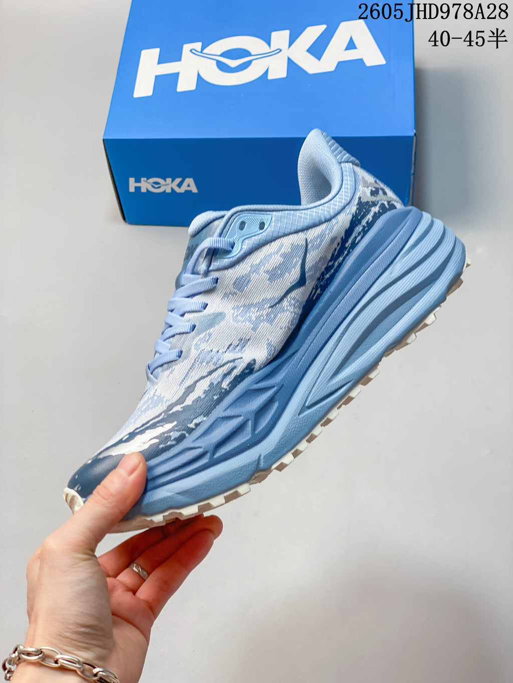Side view of the HOKA Stinson 7 showing its patterned upper and thick blue midsole
